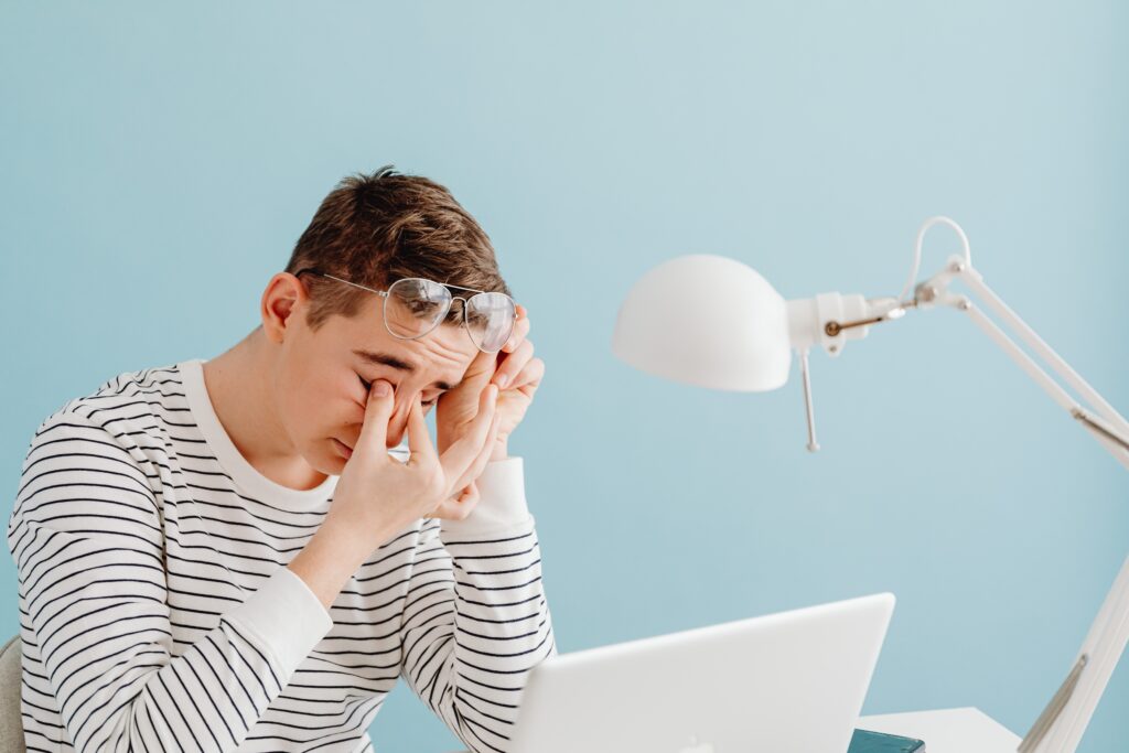 a working boy with strained eyes looking to protect vision