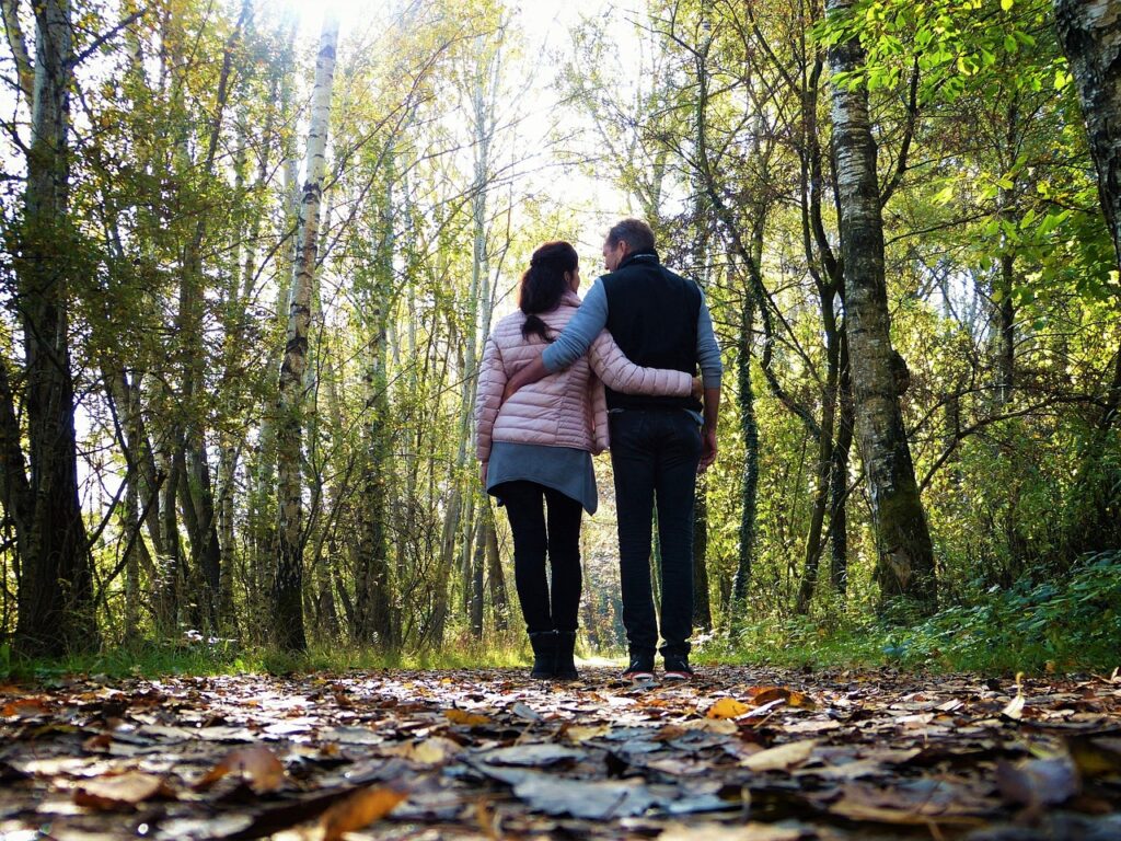 A couple walking engrossed in a forest